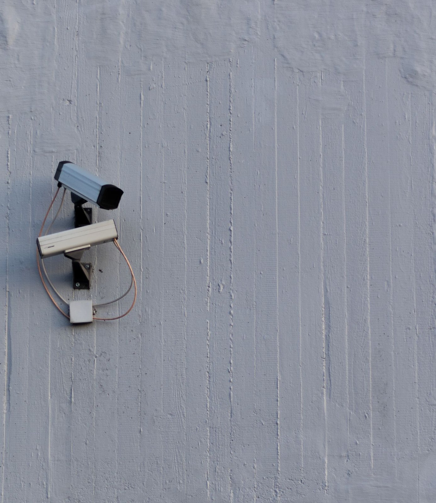 Two wall-mounted surveillance cameras covering different viewing angles